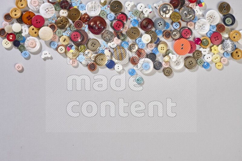 Mixed assorted buttons on grey background