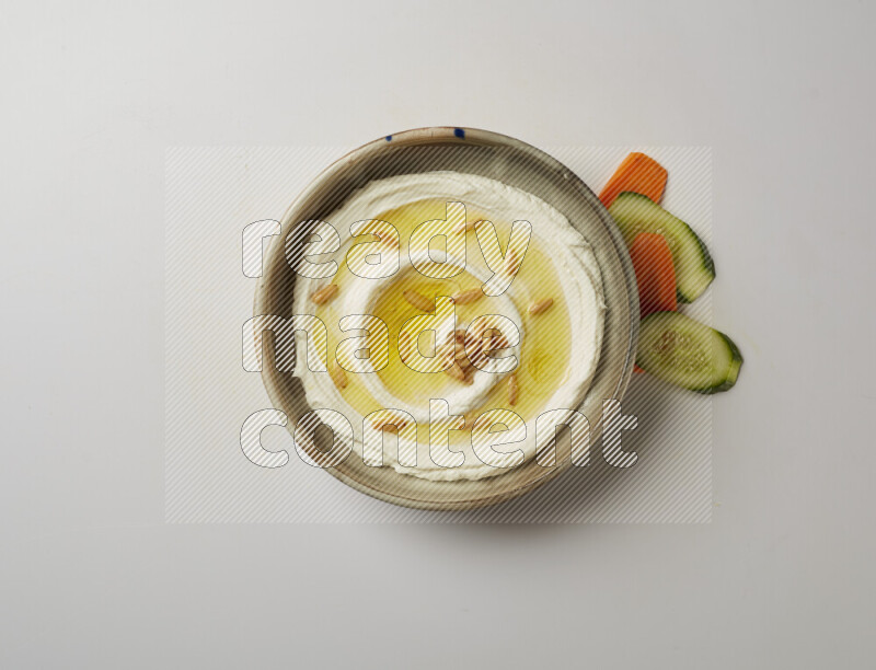 Lebnah garnished with pine nuts in a grey pottery plate on a white background