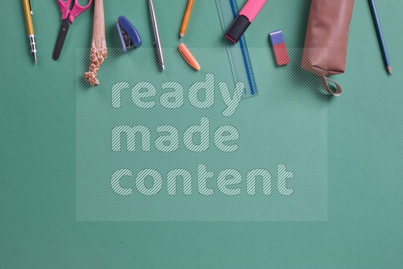 مستلزمات مدرسية مختلفة على خلفية خضراء