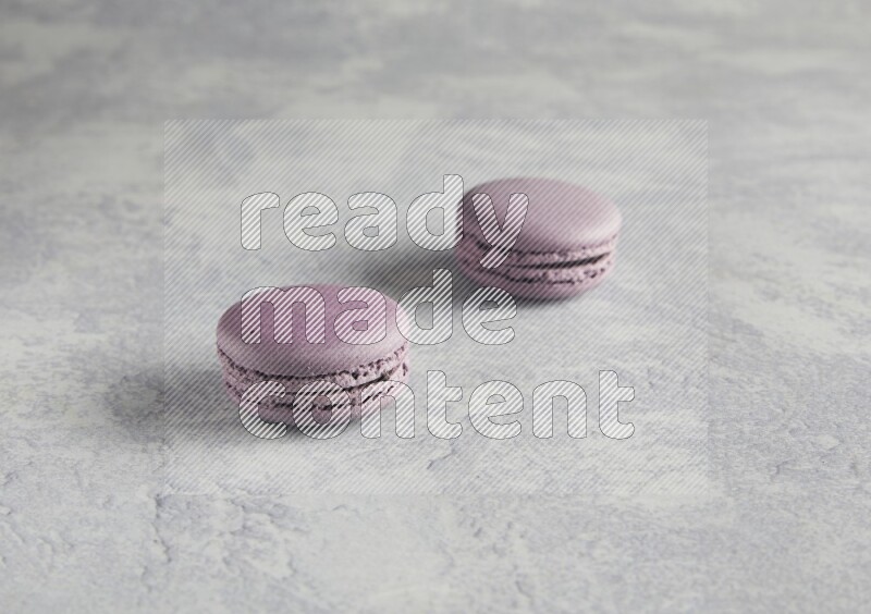 45º Shot of two Purple Blueberry macarons  on white  marble background
