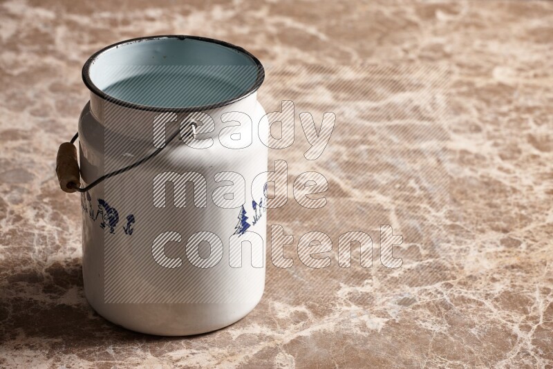 A vintage milk can on beige marble background