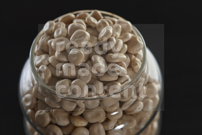 Lupin Beans in a glass jar on black background