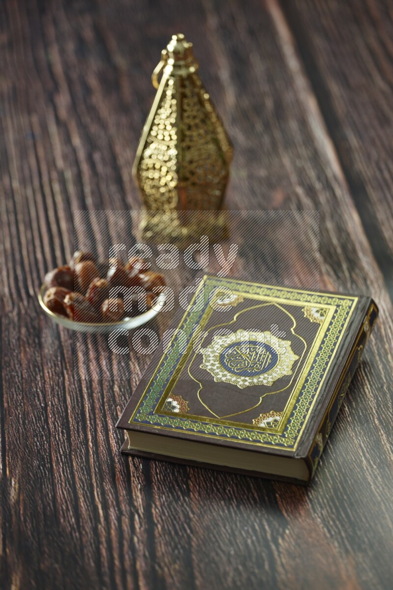 A golden lantern with different drinks, dates, nuts, prayer beads and quran on brown wooden background