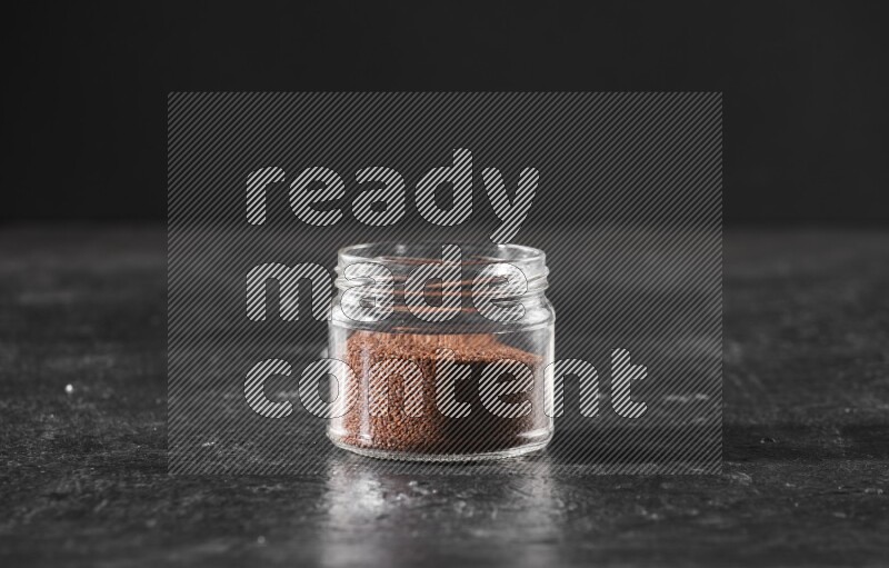 وعاء زجاجي ممتلئ ببذور حب الرشاد على أرضية سوداء