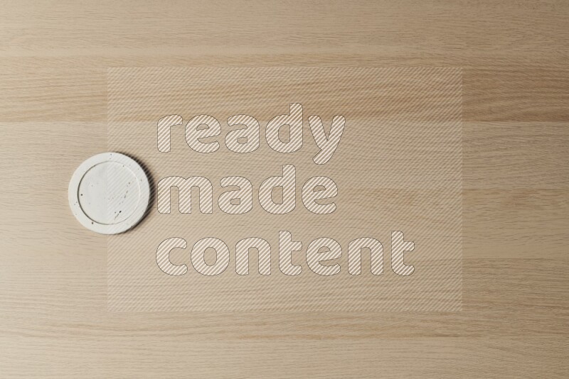 A pottery coaster on light wooden background