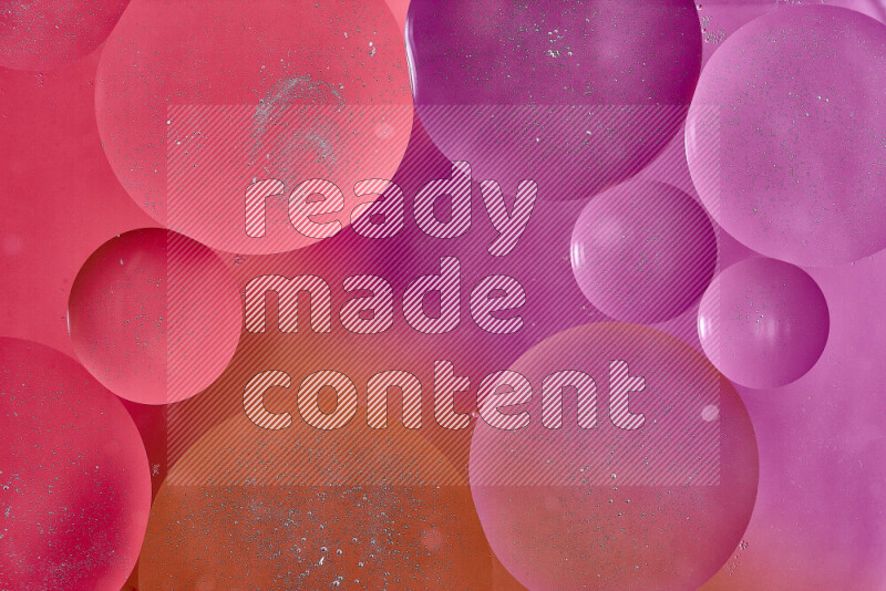 Close-ups of abstract oil bubbles on water surface in shades of red, orange and pink