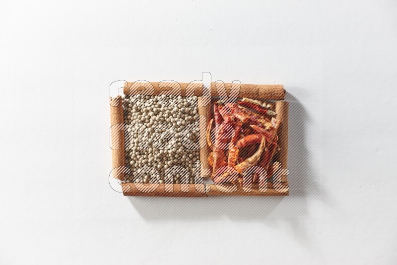 2 squares of cinnamon sticks full of red dried chilis and white pepper on white flooring