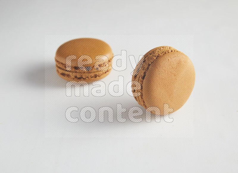 45º Shot of two Brown Maple Taffy macarons on white background