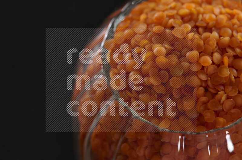 Lentils in a glass jar on black background