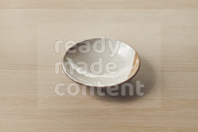 A multicolored pottery plate on light wooden background