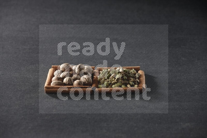 2 squares of cinnamon sticks full of nutmegs and cardamom on black flooring