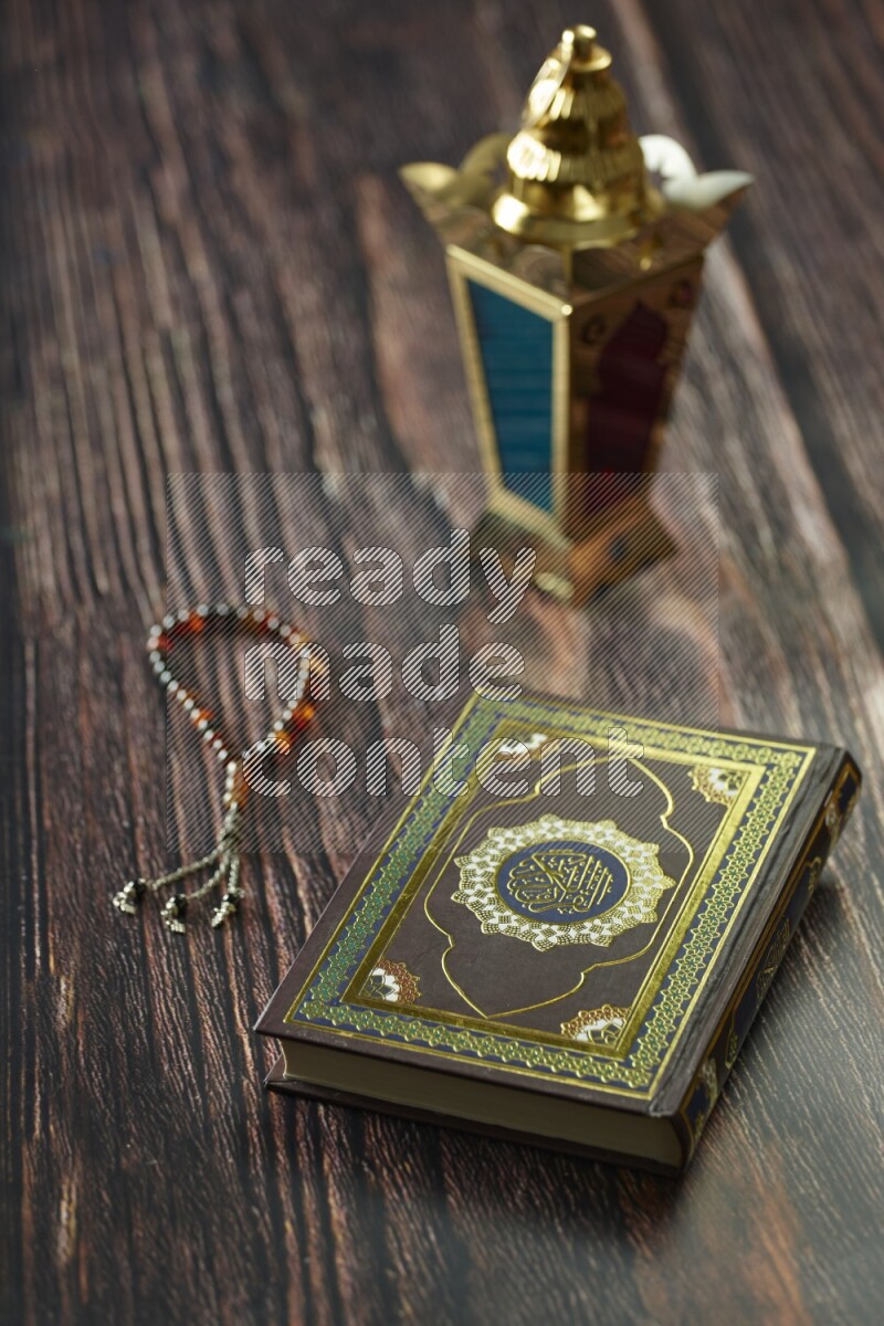 A golden lantern with different drinks, dates, nuts, prayer beads and quran on brown wooden background