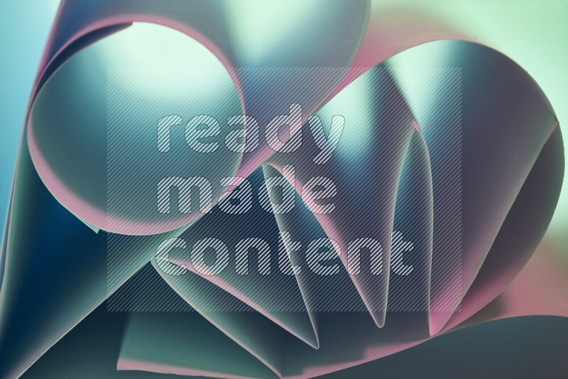 An artistic display of paper folds creating a harmonious blend of geometric shapes, highlighted by soft lighting in green and pink tones