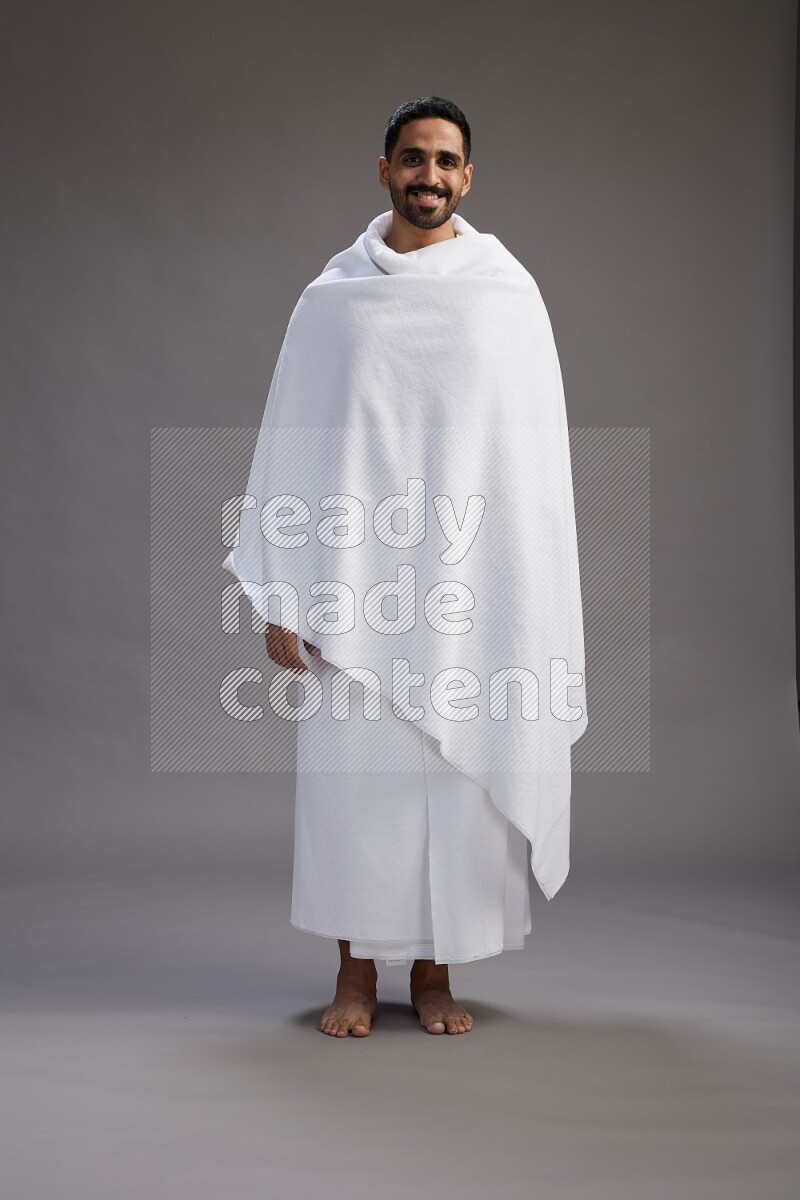 A man wearing Ehram Standing Interacting with the camera on gray background
