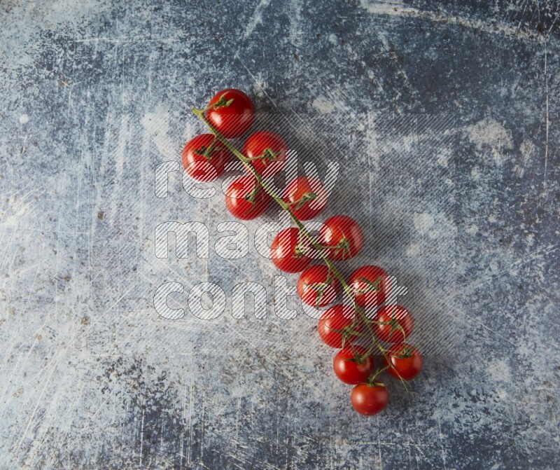Single cherry tomato vein topview on a rustic blue background