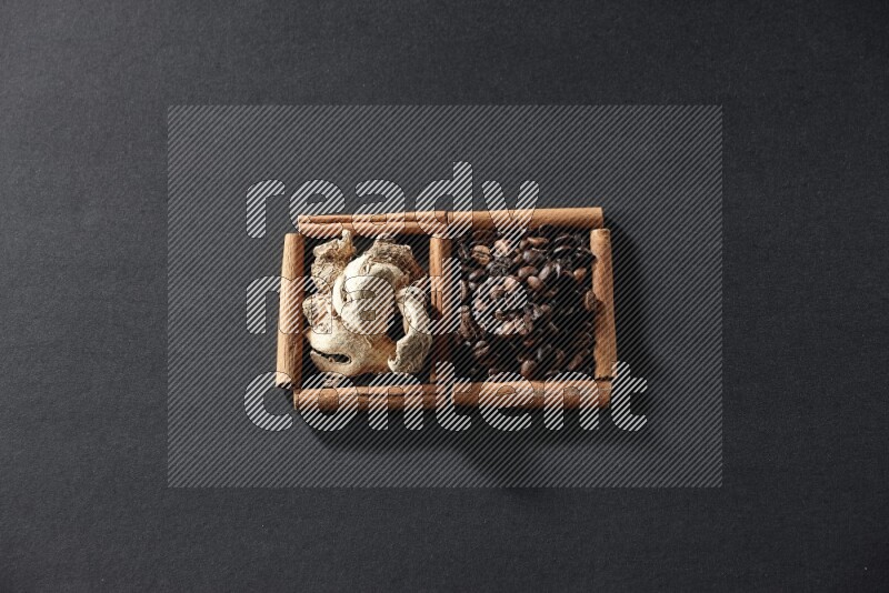 2 squares of cinnamon sticks full of coffee beans and ginger on black flooring