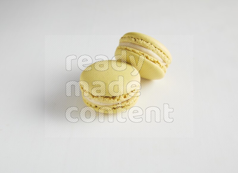 45º Shot of two Yellow Lime macarons on white background