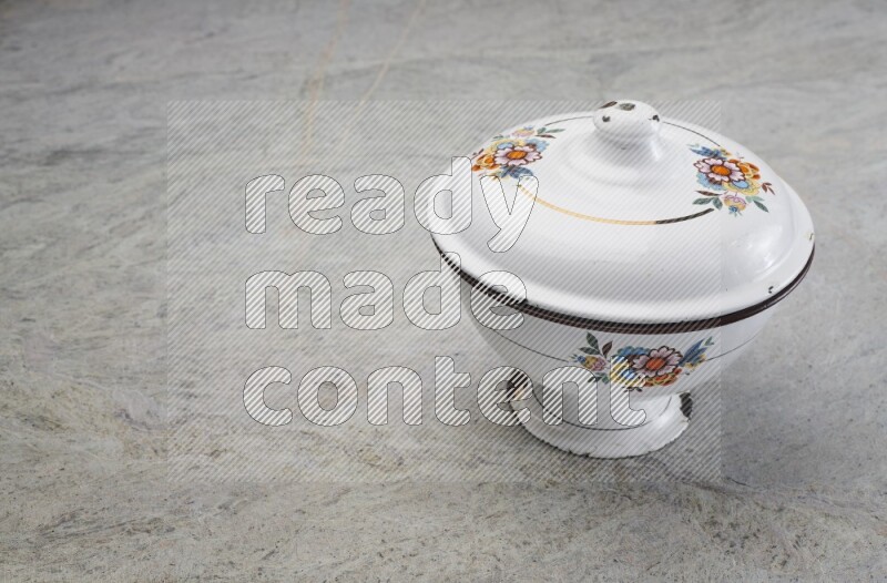 A vintage metal pot on grey marble background
