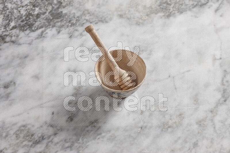 Decorative pottery bowl with wooden honey dipper in it on grey marble background