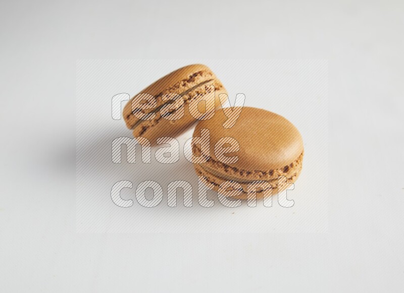 45º Shot of two Brown Maple Taffy macarons on white background