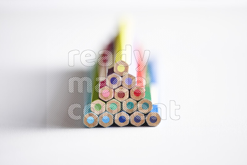 A close-up of the tips of colored pencils arranged in a bundle on white background