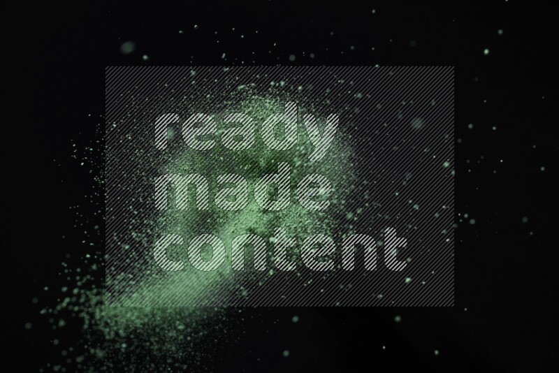 Green powder explosion on black background