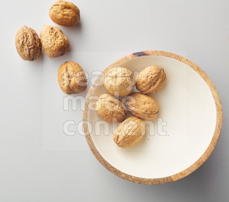 Top-view shot of walnut in a container on white background