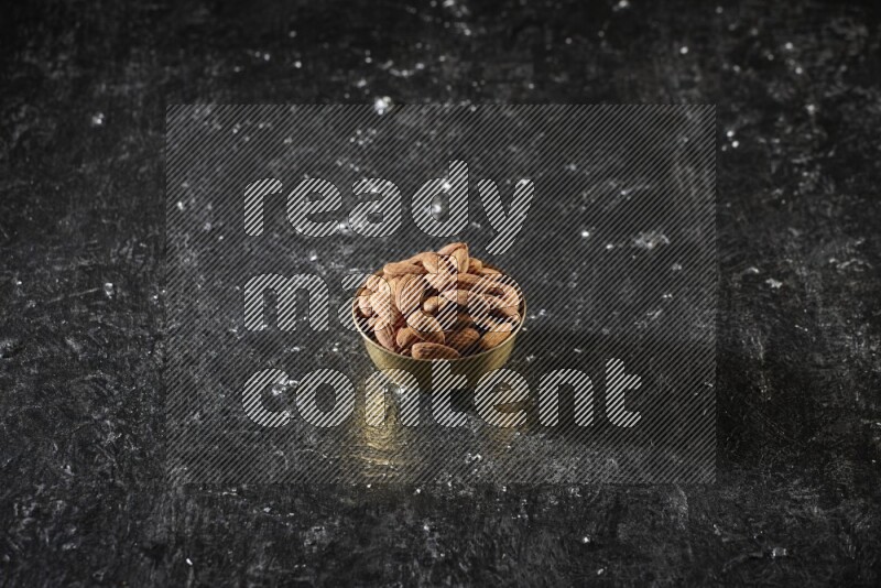 مكسرات في وعاء معدني علي خلفية سوداء