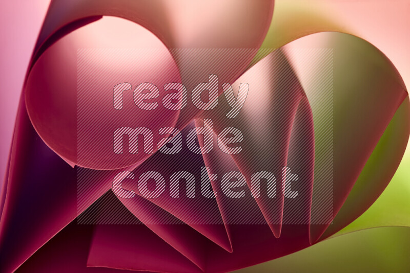 عرض فني لطيات الورق تخلق مزيج من الأشكال الهندسية، مضاءة بإضاءة ناعمة بدرجات اللون الأخضر والأحمر