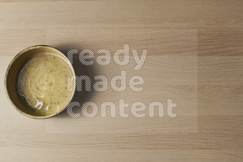A multicolored pottery oven plate on light wooden background
