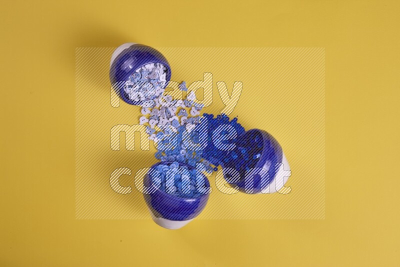 مجموعة من أدوات الخياطة والتفصيل زرقاء اللون على خلفية صفراء