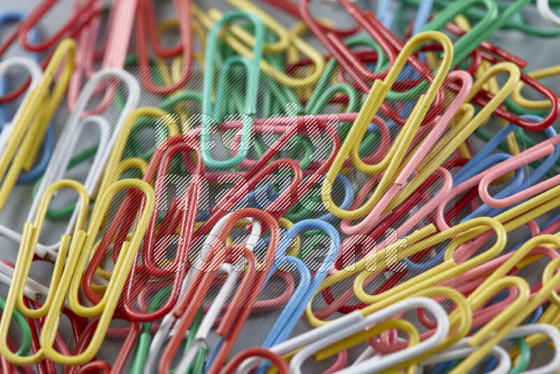 Multicolored paper clips isolated on a grey background
