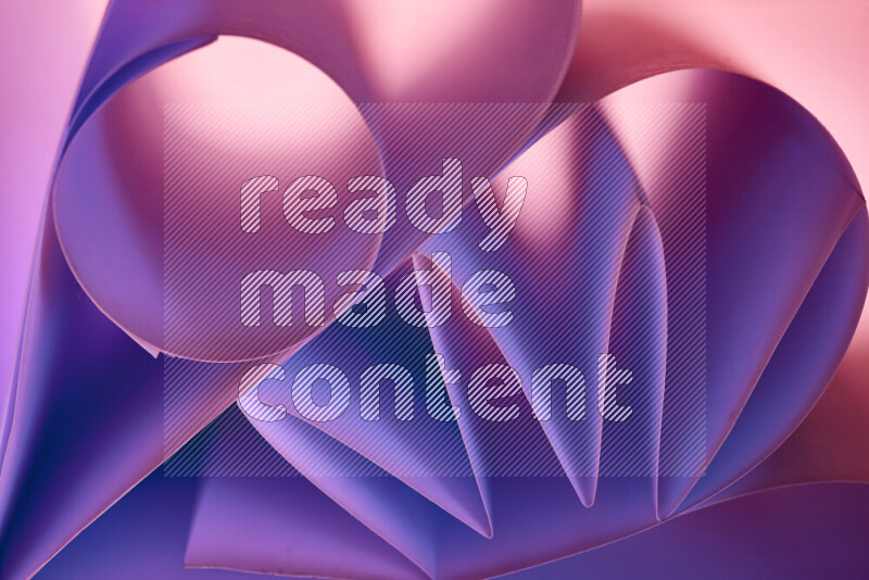 An artistic display of paper folds creating a harmonious blend of geometric shapes, highlighted by soft lighting in purple tones