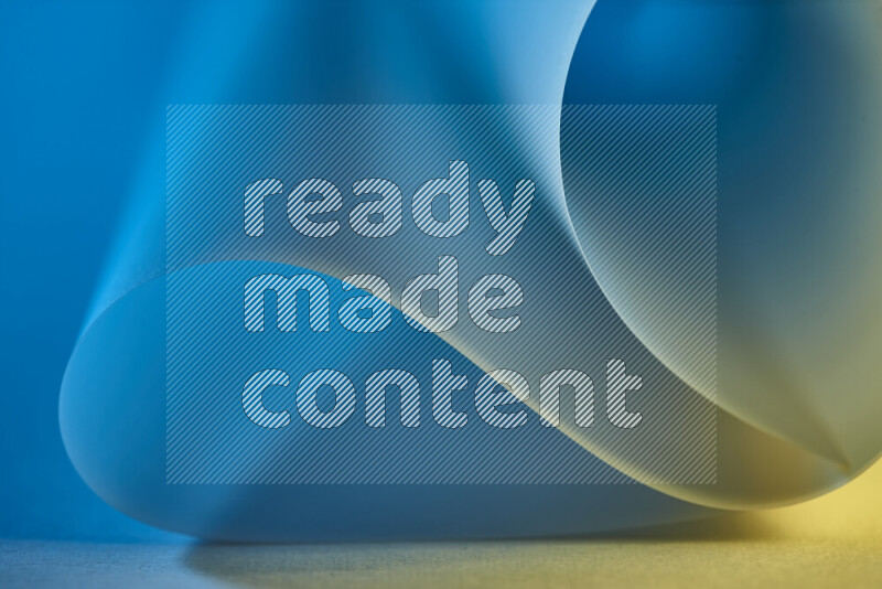 فن تجريدي يعرض منحنيات وتدرجات اللون الأزرق والذهبي مكونه بضوء ملون