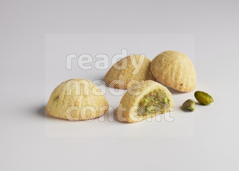 Four Pieces of Maamoul filled with pistachio  paste one of them is cut direct on white background
