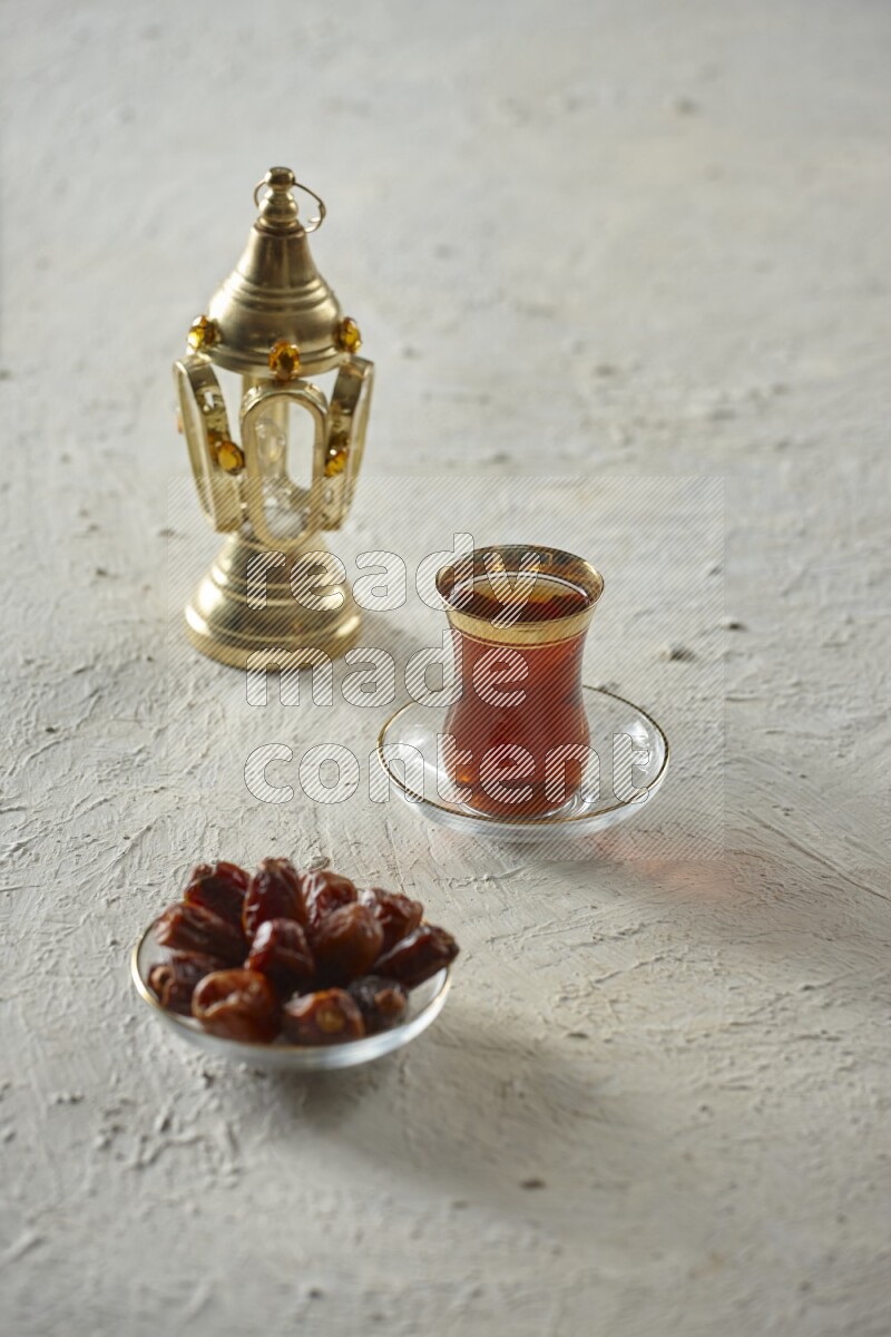 A golden lantern with different drinks, dates, nuts, prayer beads and quran on textured white background