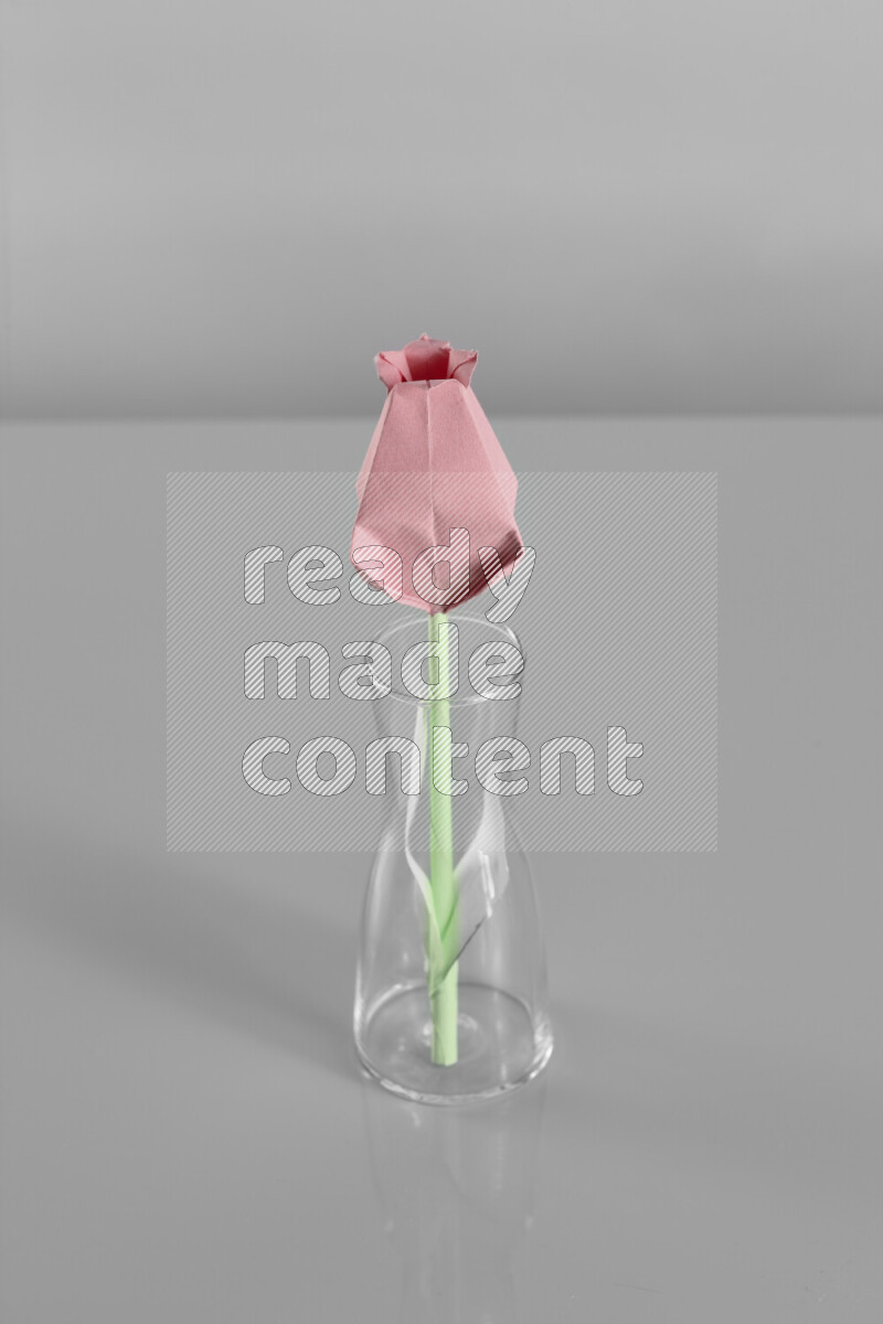 Origami flower on grey background