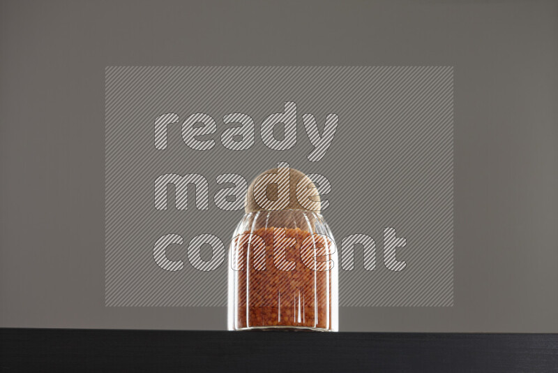 Lentils in a glass jar on black background