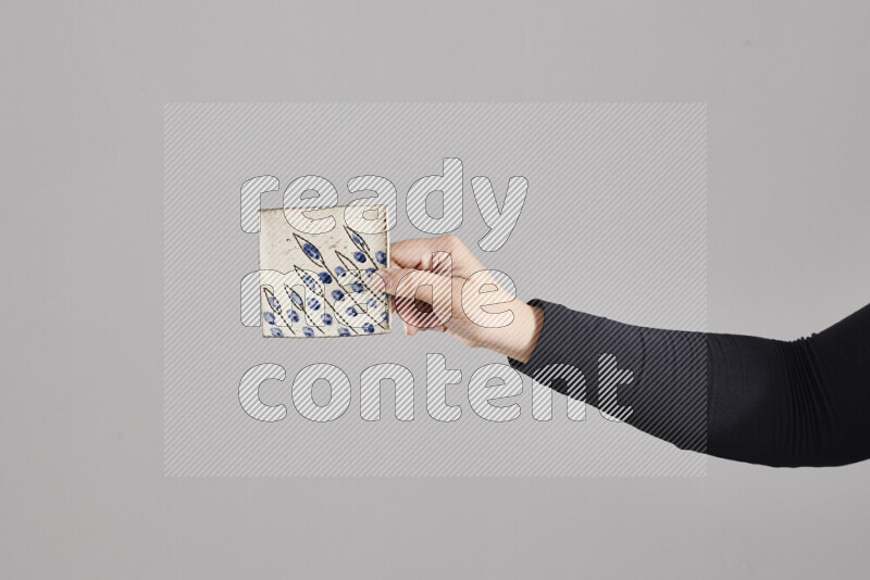 A woman in black abaya holding different pottery essentials in different positions