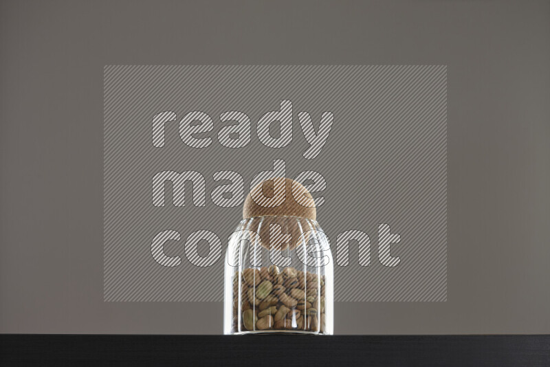 Fava beans in a glass jar on black background