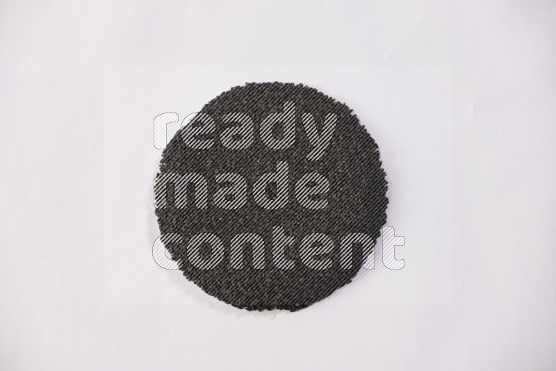Black seeds in a circle shape on a white flooring
