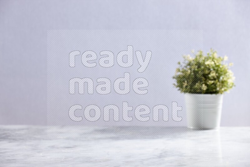Artificial plant in white pot on grey marble background