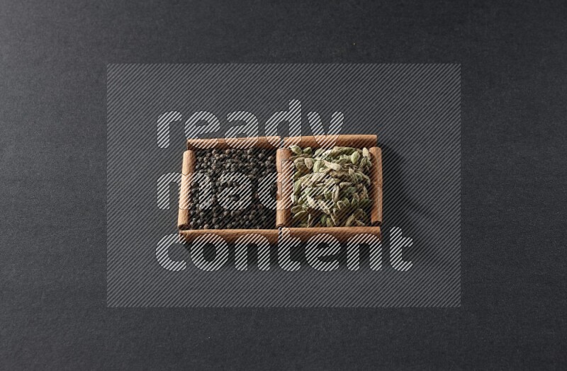 2 squares of cinnamon sticks full of black peppers and cardamom on black flooring