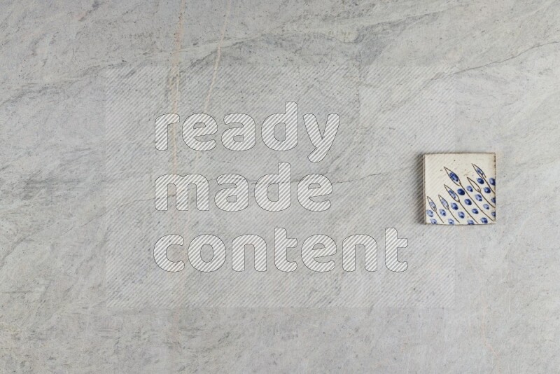 A decorative pottery coaster on grey marble background