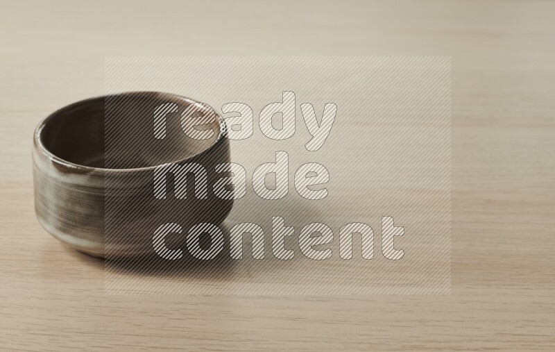 A multicolored pottery bowl on light wooden background