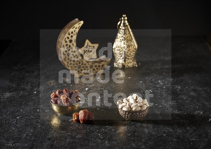 تمر في وعاء معدني مع الفستق بجانب فوانيس ذهبية علي خلفية سوداء