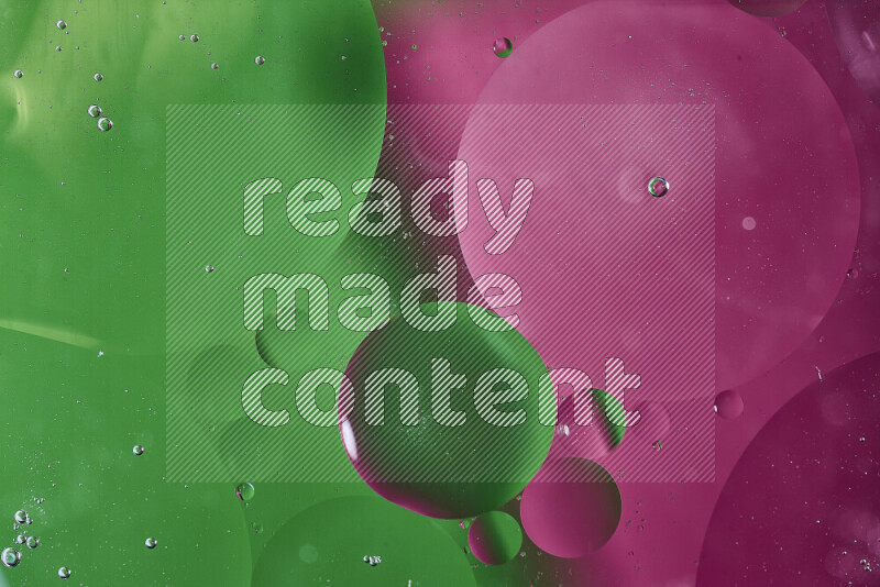 لقطات مقربة لفقاعات من الزيت على سطح الماء باللون الأخضر والوردي