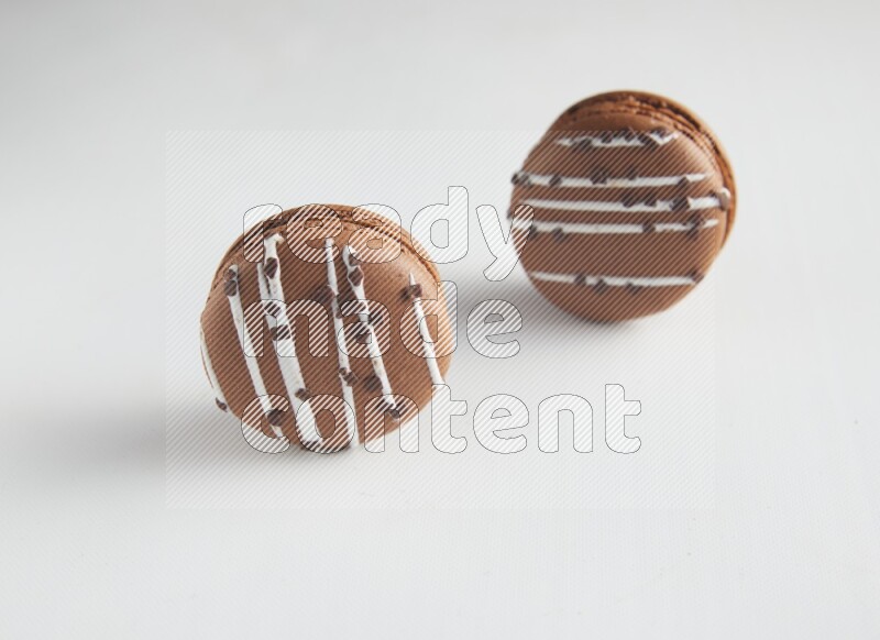 45º Shot of two Brown white Chocolate Caramel macarons on white background