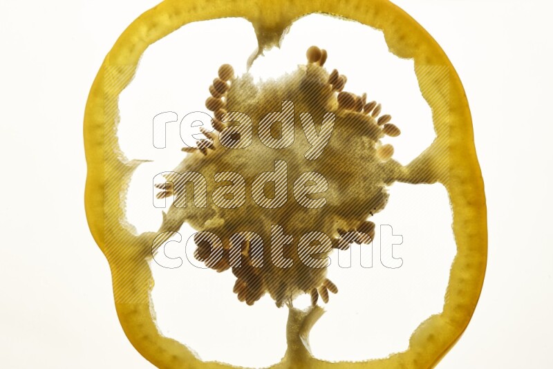 Yellow bell pepper slices on illuminated white background