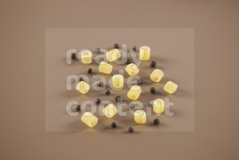 معكرونة مع مكونات متنوعة من الطماطم والثوم والبصل والفلفل الأحمر والفلفل الأسود والفلفل الأبيض وأوراق الغار وإكليل الجبل والهيل على خلفية بيج